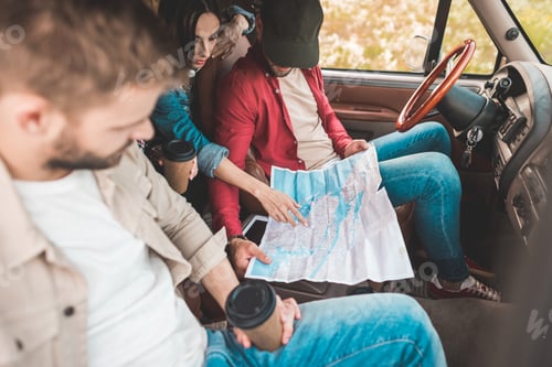 Preview: young travelling friends navigating while sitting in car