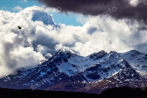 Preview: Scenic landscape featuring snowy mountains under a dramatic sky in Isle of Skye, Scotland, UK