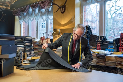 Preview: Tailor examining roll of cloth in tailor shop