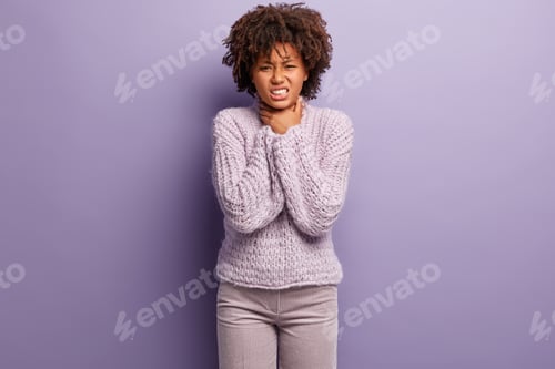 Preview: Stressed lady suffers from asthma or suffocation, has obstruction, keeps hands on neck, wears jumper