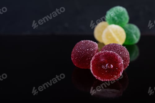 Preview: Colorful marmalade isolated on dark background. Delicious jujube balls.