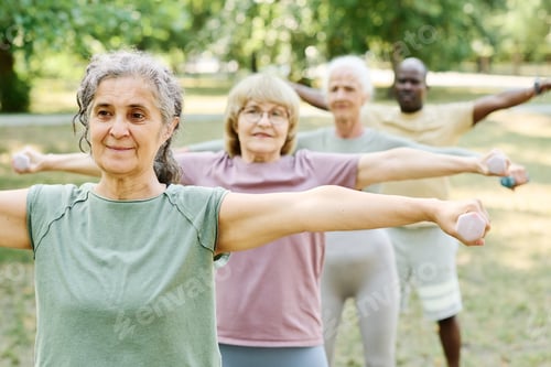 Preview: Senior people exercising with dumbbells outdoors