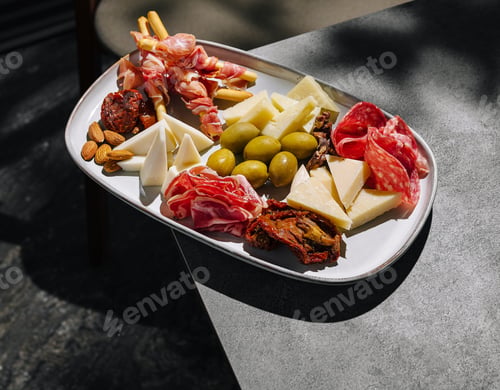 Preview: Delicious charcuterie board with meats, cheeses, and nuts in outdoor setting