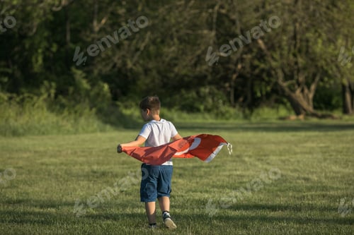 Preview: Boy holding Turkey flag. Kid hand waving Turkish flag view from back, copy space for text
