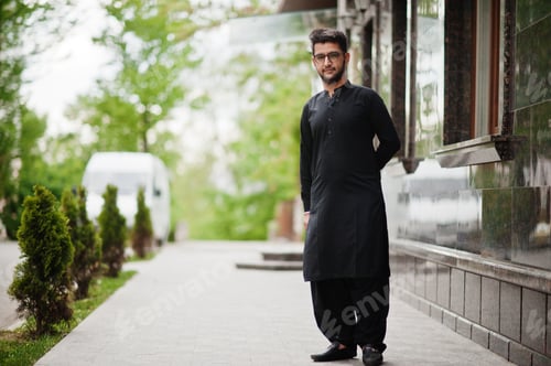 Preview: Pakistano bangladesh man wear black traditional clothes and eyeglasses pose outdoor.
