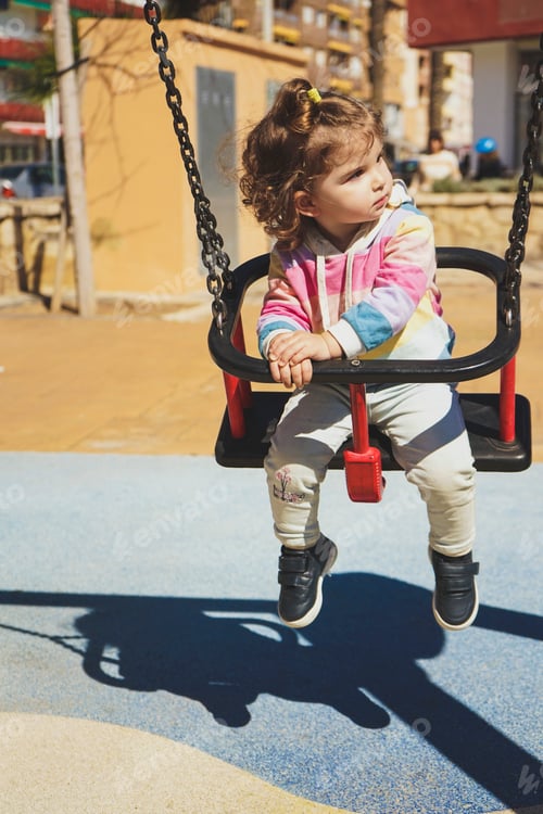 Preview: Distracted baby during the playtime sitting in a swing