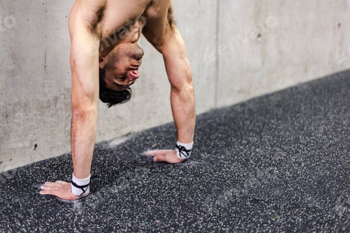 Preview: Man doing handstand in gym