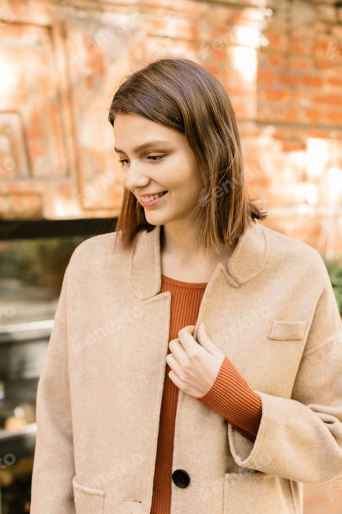Preview: Young beautiful stylish woman walking in street in warm autumn outfit.