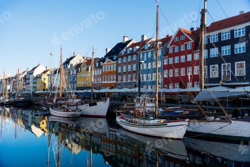 Preview: COPENHAGEN, DENMARK - 06 MAY, 2018: Nyhavn pier with buildings, yachts and boats reflected in water,