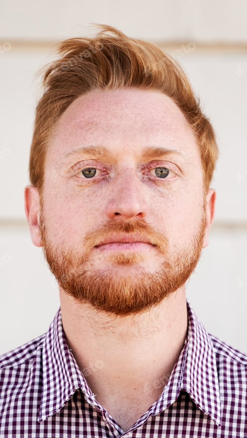 Preview: Outdoor Vertical portrait of a Red hair guy looking at the camera serious with serene face. Close up