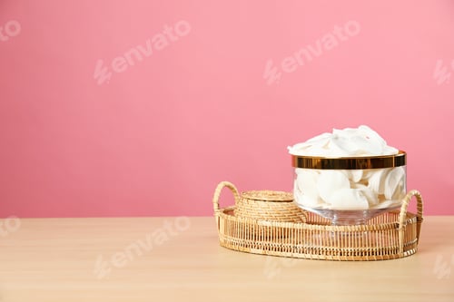 Preview: Jar with cotton pads on wooden table against pink background. Space for text