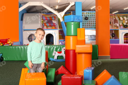 Preview: Cute child playing with colorful building blocks indoors