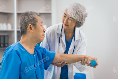 Preview: Asian people mature woman doctor giving male elderly patient through indoor physical therapy