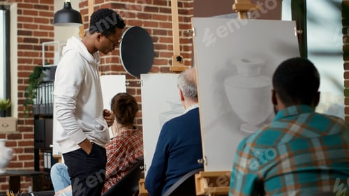 Preview: Young man looking at elder student drawing vase model