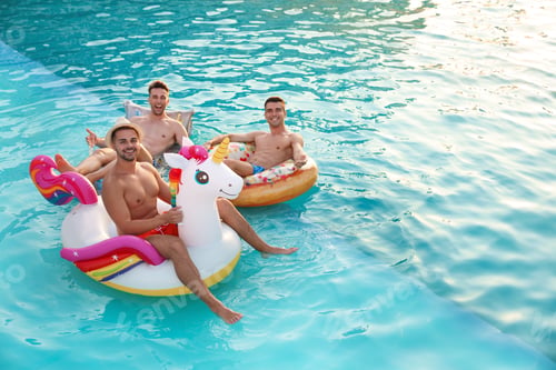 Preview: Happy young friends relaxing in swimming pool