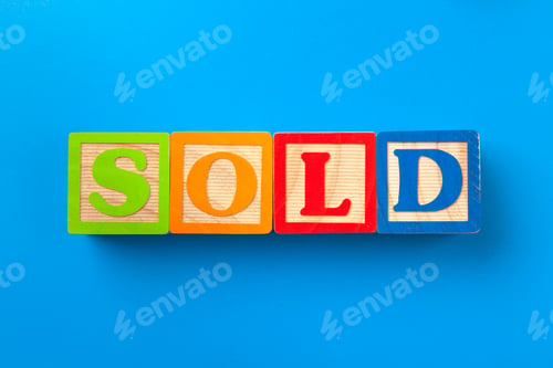 Preview: Sold. Wooden colorful alphabet blocks on blue background, flat lay, top view
