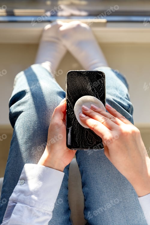 Preview: Woman cleaning cellphone to eliminate germs, coronavirus, covid-19, bacterias. New normal