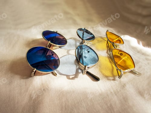 Preview: three pairs of sunglasses yellow, blue and mirror glasses on a linen background