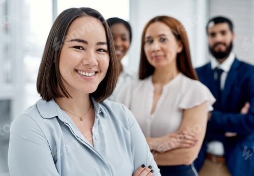 Preview: Portrait of a businesswoman standing in an office with her colleagues in the background