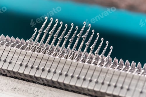 Preview: Close up detail of steel latch needles on a knitting machine