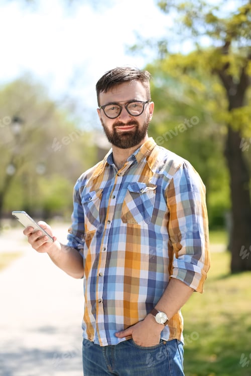Preview: Portrait of young man with smartphone outdoors