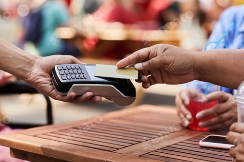 Preview: Senior woman paying with credit card in outdoor cafe