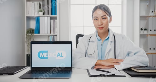 Preview: Confident young Asia female doctor in white medical uniform with stethoscope looking at camera.