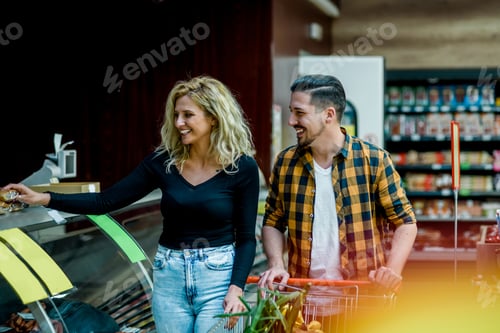 Preview: Couple in a supermarket with shopping cart while grocery shopping