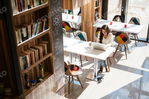 Preview: Young Woman Works on Laptop in Bright Space