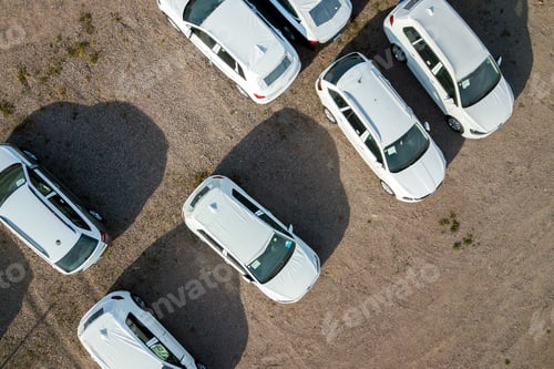 Preview: Many brand new cars covered in protective foil on sale parked outside on dealer parking lot