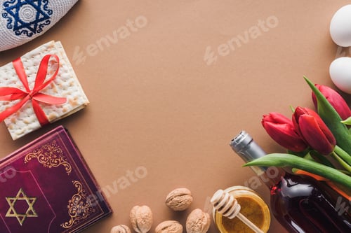 Preview: top view of traditional book with text in hebrew, wine and matza on brown table