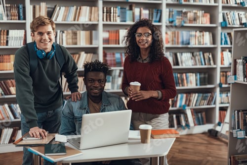 Preview: Positive Emotional Young Afro-American Student Sitting At The Table With Modern Laptop While His