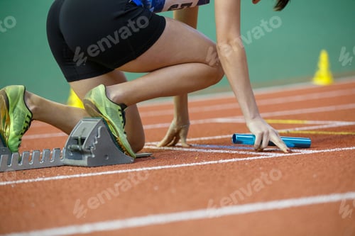 Preview: Runner preparing at starting blocks for a relay race during a track event