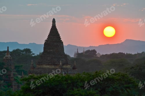 Preview: Sunset over distant mountains with stupa of temple in the foreground, Bagan, Myanmar.