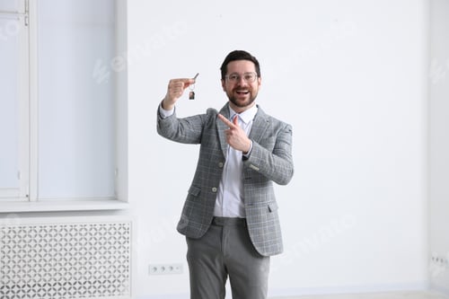 Preview: Real estate agent holding key with house shaped keychain indoors