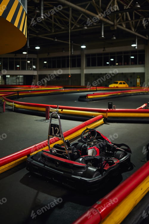 Preview: design of racing car inside of indoor kart circuit, red motor race vehicle with number twelve