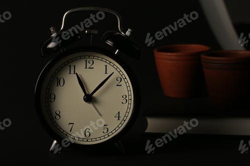Preview: A Black Book And A Black Watch Stand Against A Black Background