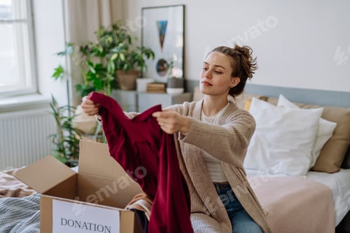 Preview: Young woman giving her clothes to charity.