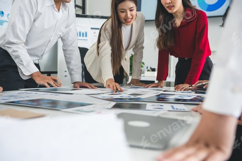 Preview: Business team analyzing marketing data on office desk