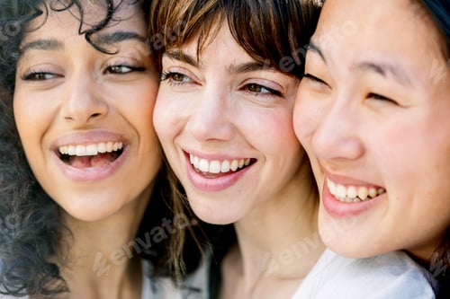 Preview: Close-up portrait of three young girls joining faces for portrait.