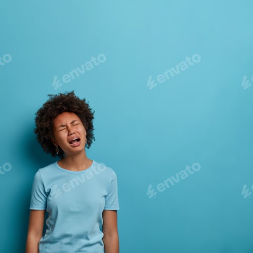 Preview: Vertical shot of disappointed desperate melancholic woman cries loudly from despair, keeps mouth ope