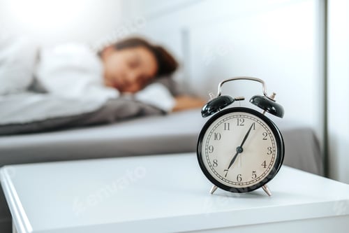 Preview: Close up Clock on the bed Asian woman wake up and disturbed by alarm clock early morning