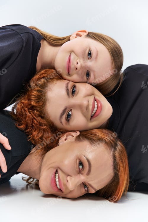 Preview: three generations concept, happy women and girl smiling and looking at camera on grey backdrop