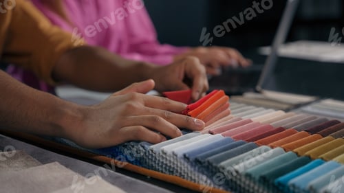 Preview: Close up details woman assistant and man designer choosing color fabric samples hands touch textile