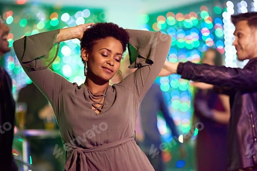 Preview: Moving to the beats. Shot of a beautiful young woman dancing in a nightclub.