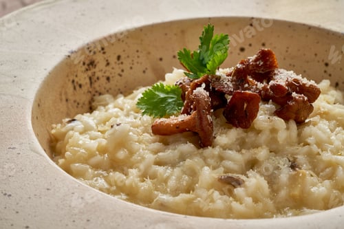 Preview: Risoto with chanterelle mushrooms in large plate. Side view, close up