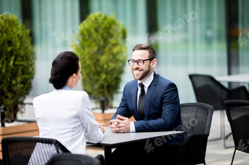 Preview: Smiling man and woman sitting at cafe and having dialogue