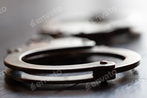 Preview: Closeup shot of a metal handcuffs on a white background