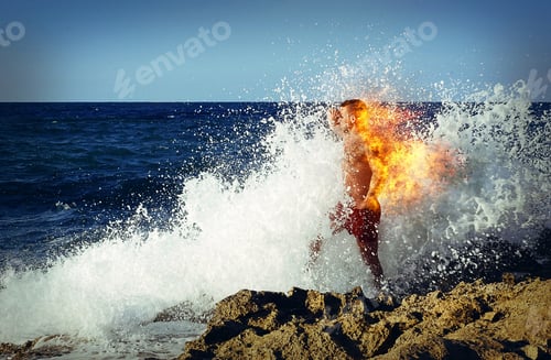 Preview: Man standing on rock and looking at sea in large splashes and burning