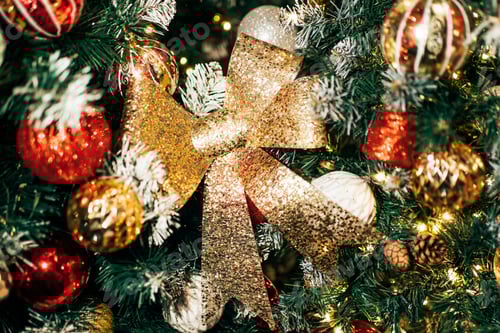 Preview: Christmas tree decorating with glittering gold bow and ornaments